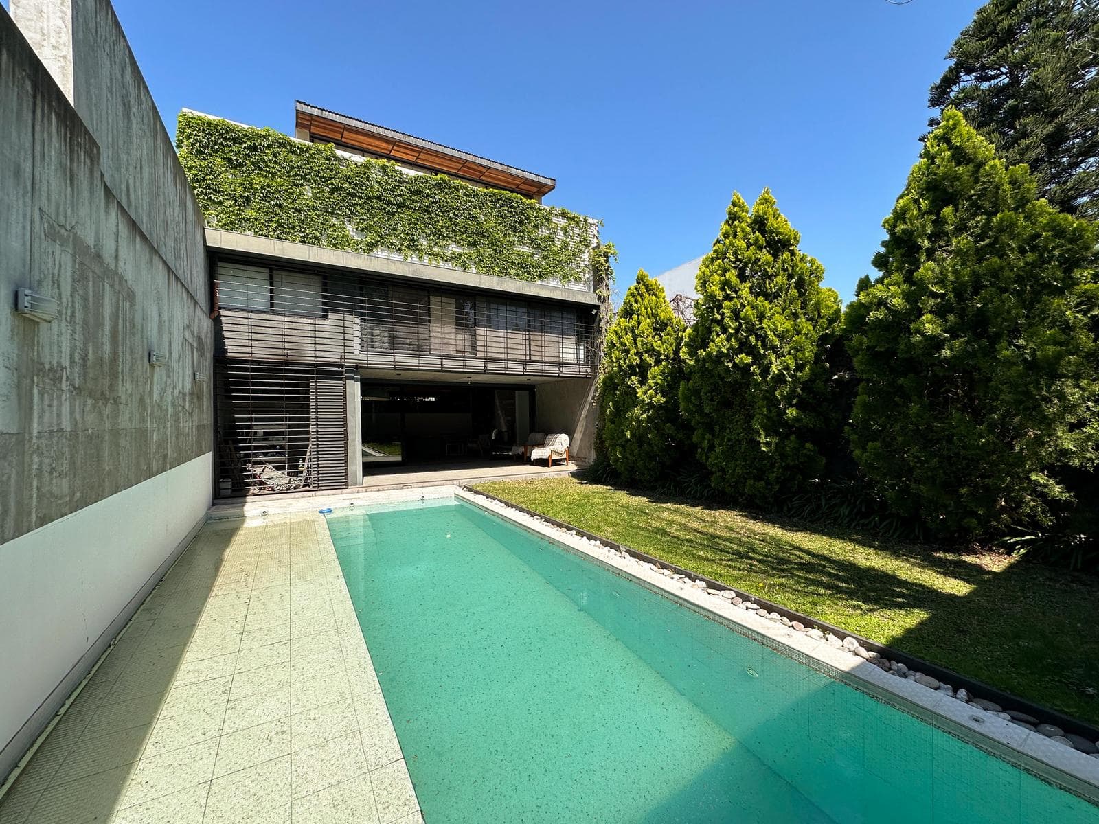 Designer home with 3 bedrooms, 2 garage spaces, a garden, and a pool