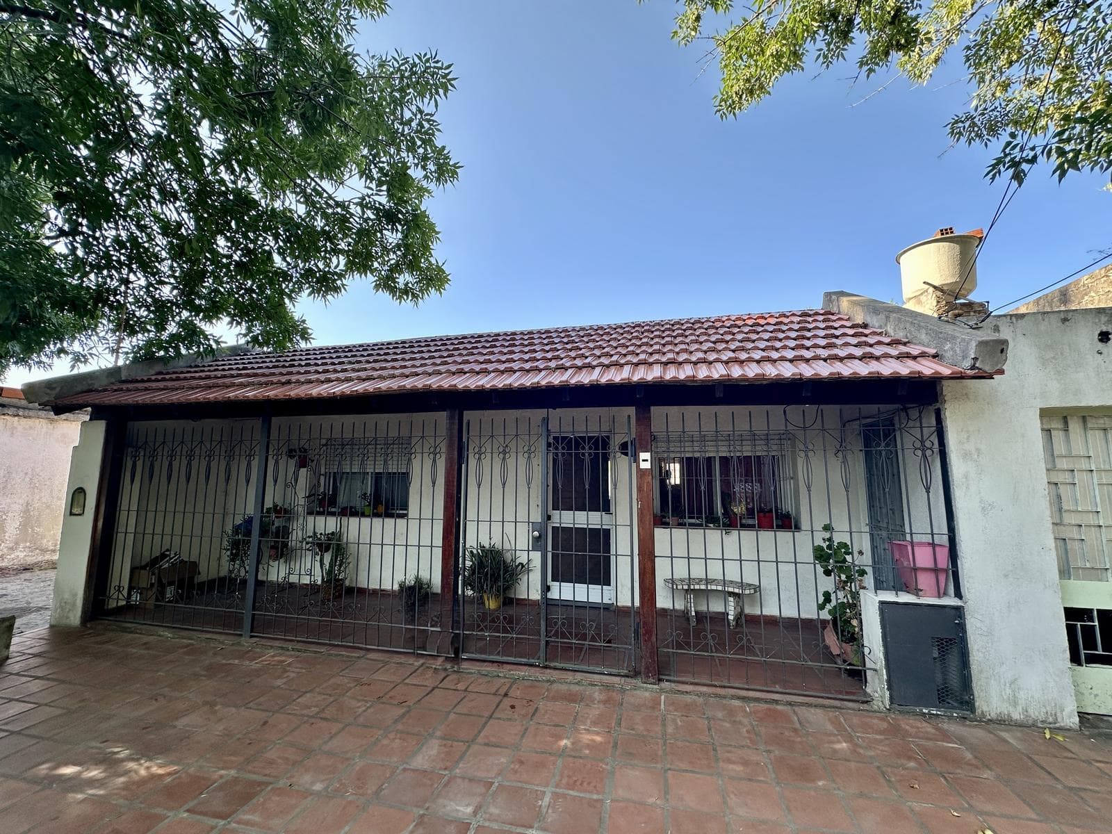 2-bedroom house for sale. Porch with laundry area. Backyard with grill. Range hood